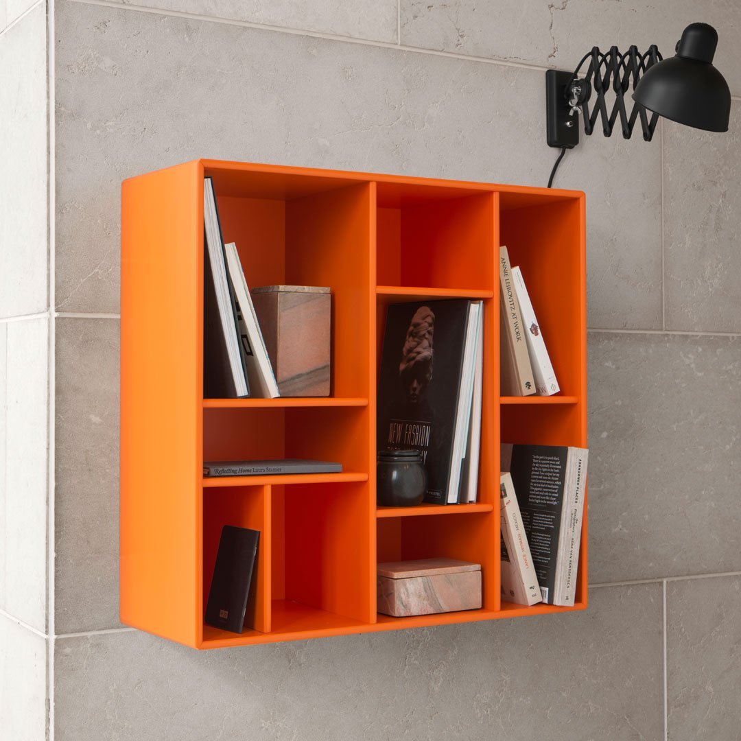 Bright orange wall-mounted bookshelf with a sleek design, featuring rectangular compartments for books and decor.