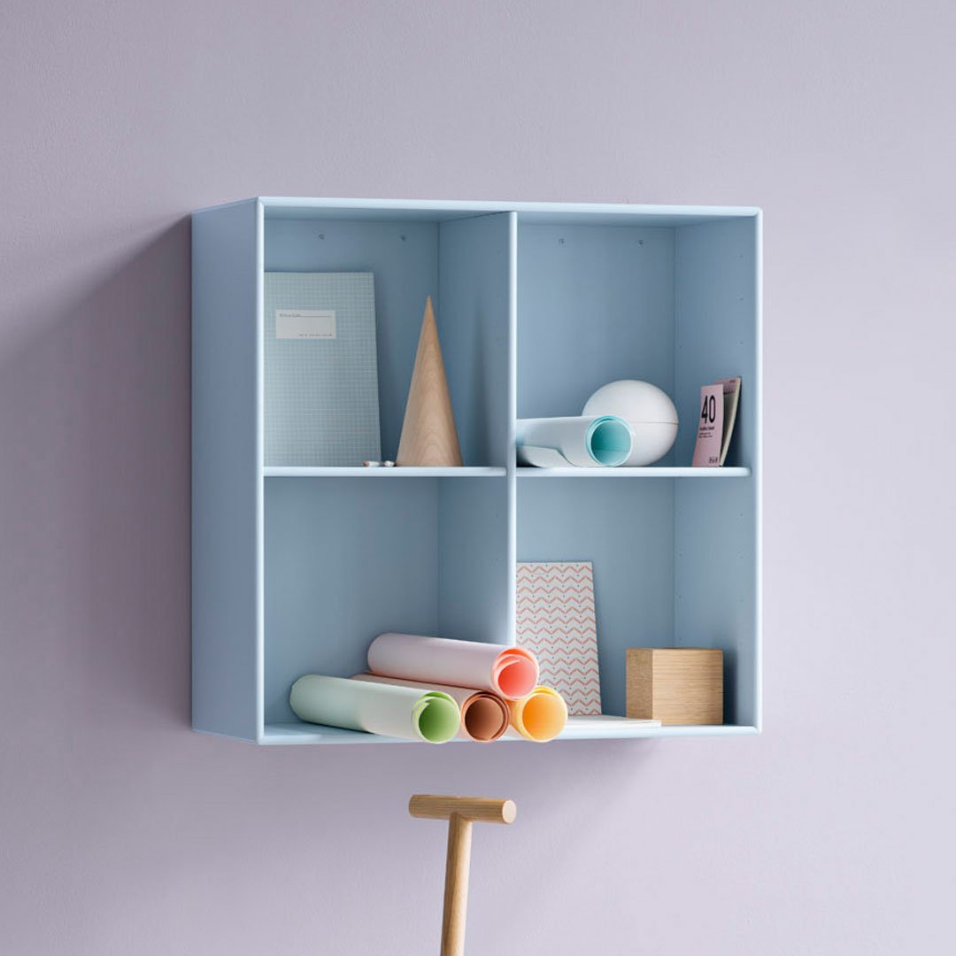 Light blue wall shelf with pastel-colored rolls, geometric decor, and soft pink background. Modern, minimalist design.