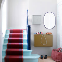 Rustic red and navy striped stair runner on mint blue steps, paired with a gold storage box and pink woven basket.