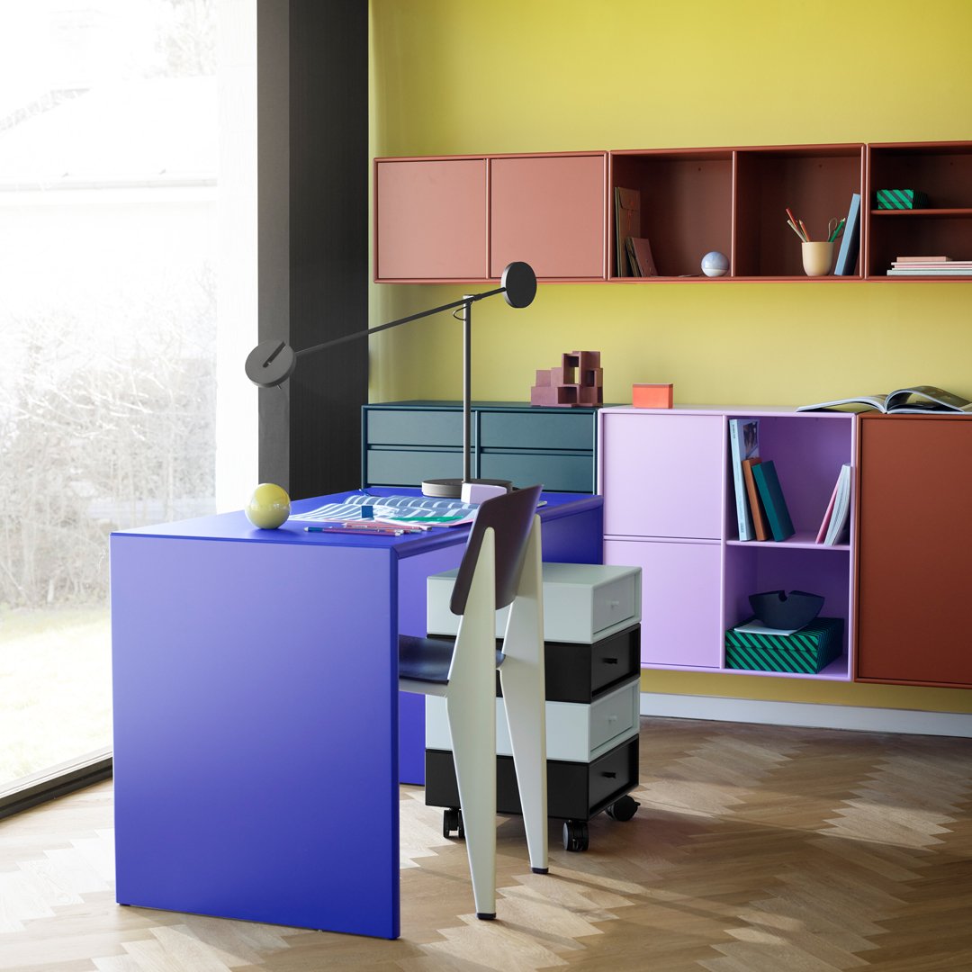 Colorful modern workspace featuring purple desk, patterned storage, and vibrant yellow wall. Stylish and functional design.