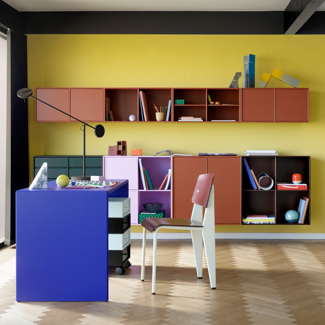 Colorful modern workspace featuring yellow walls, purple desk, and multicolored storage cabinets with geometric patterns.