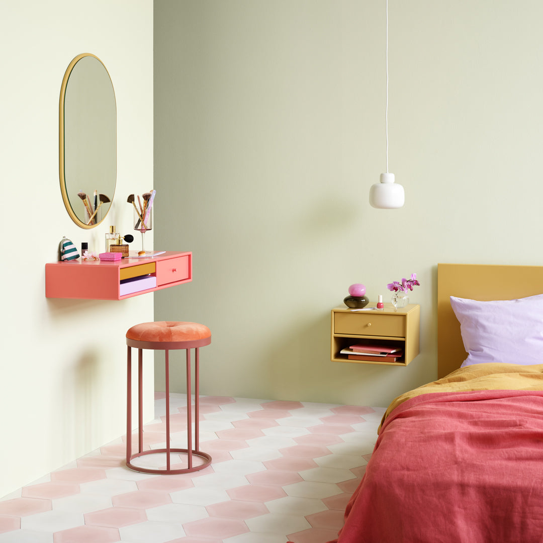 Colorful bedroom featuring a pink patterned floor, mint green walls, and vibrant orange and gold furnishings.