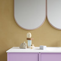 Purple cabinet with a white top, featuring pastel blocks and natural stone accents against a golden wall background.