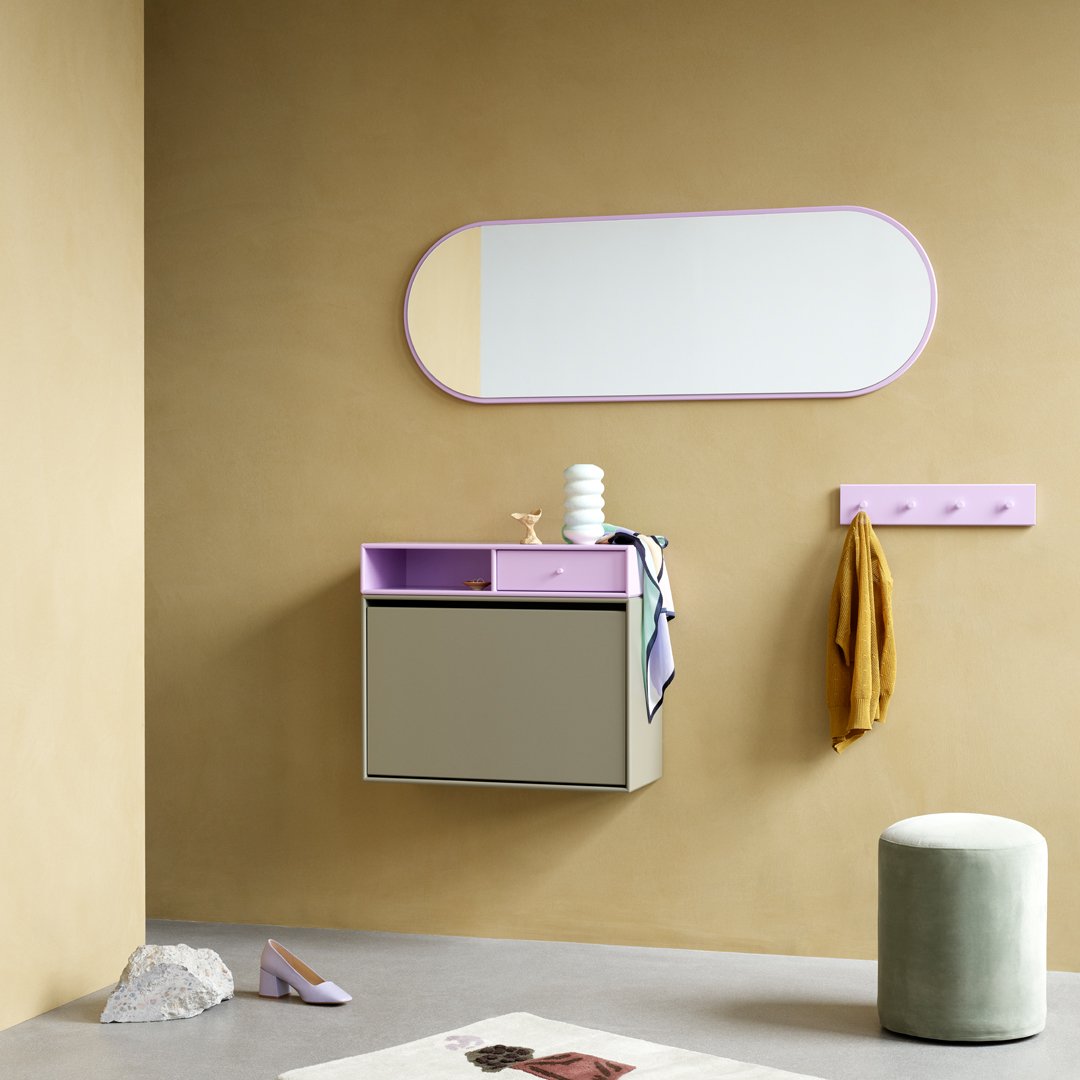 Stylish wall-mounted cabinet in grey and pastel purple, paired with a mint green stool and warm beige wall.