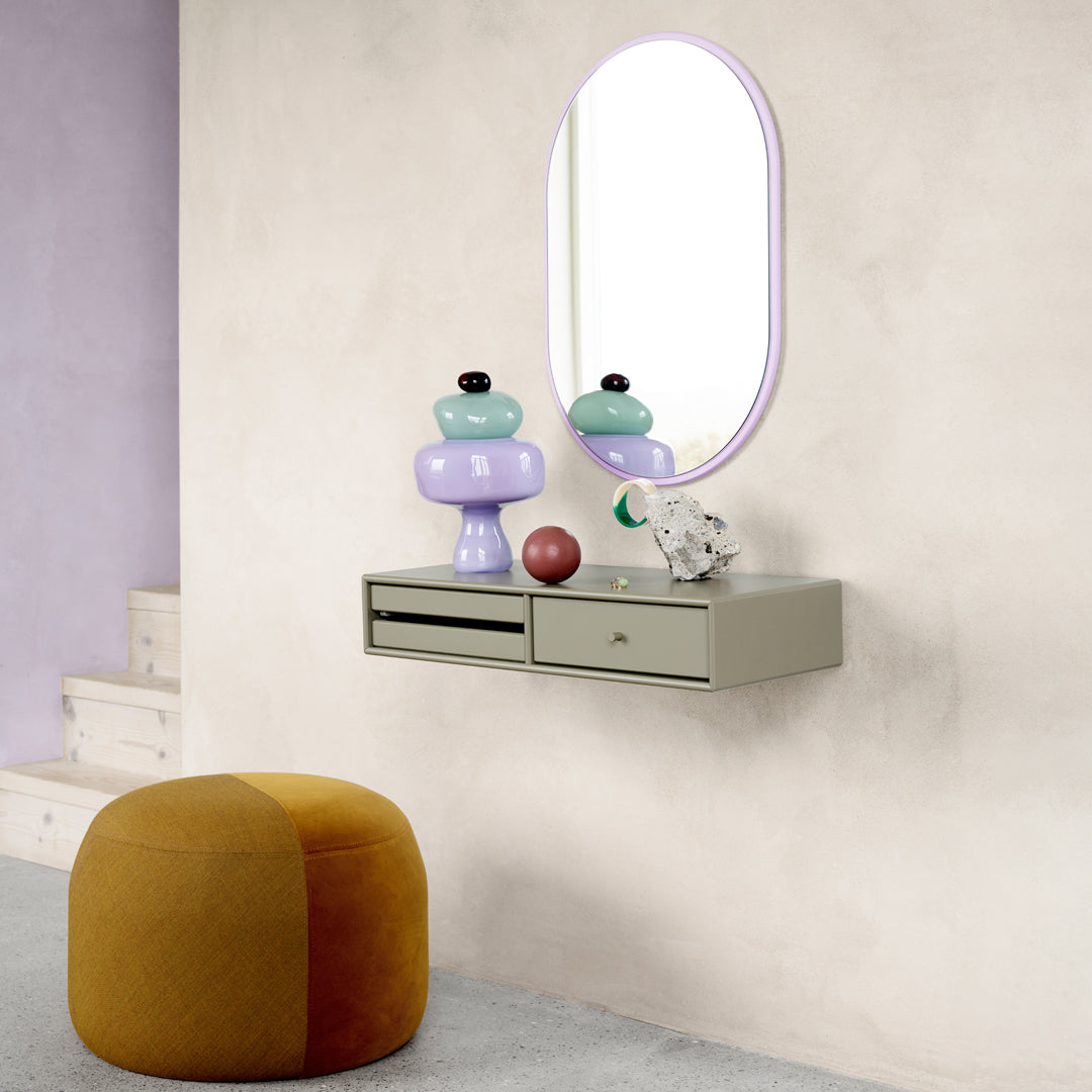Colorful decor: mint green, lavender, black, and earthy tones on a wall shelf with a round mirror.