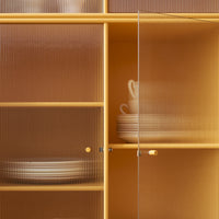 Yellow glass cabinet with ribbed texture, showcasing cream-colored tableware and an orange interior.