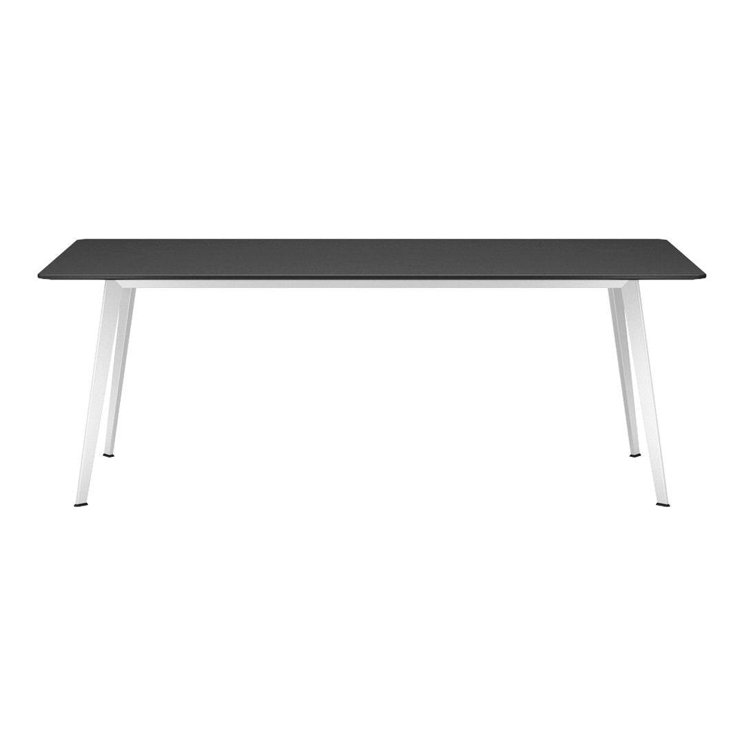 Modern black rectangular table with sleek white metal legs, showcasing a minimalist design and neutral color palette.