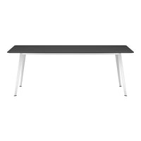 Modern black rectangular table with sleek white metal legs, showcasing a minimalist design and neutral color palette.