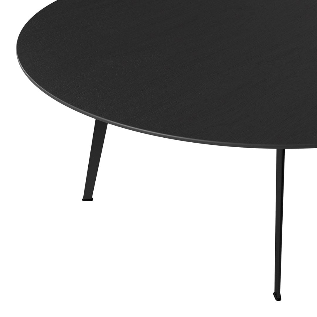 Black round table with a smooth surface and sleek black metal legs. Minimalist design perfect for modern decor.