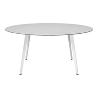 Round white dining table with sleek white legs, featuring a smooth, minimalist surface and modern design.