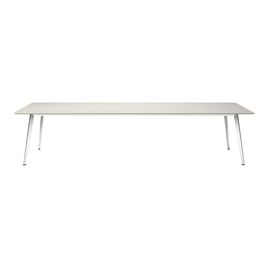 Modern rectangular table in a light beige surface with sleek white metal legs, creating a minimalist aesthetic.