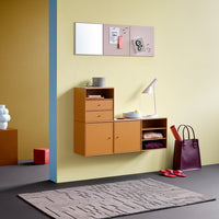 "Modern furniture in warm orange and burgundy with yellow walls and a textured gray rug, featuring geometric patterns."