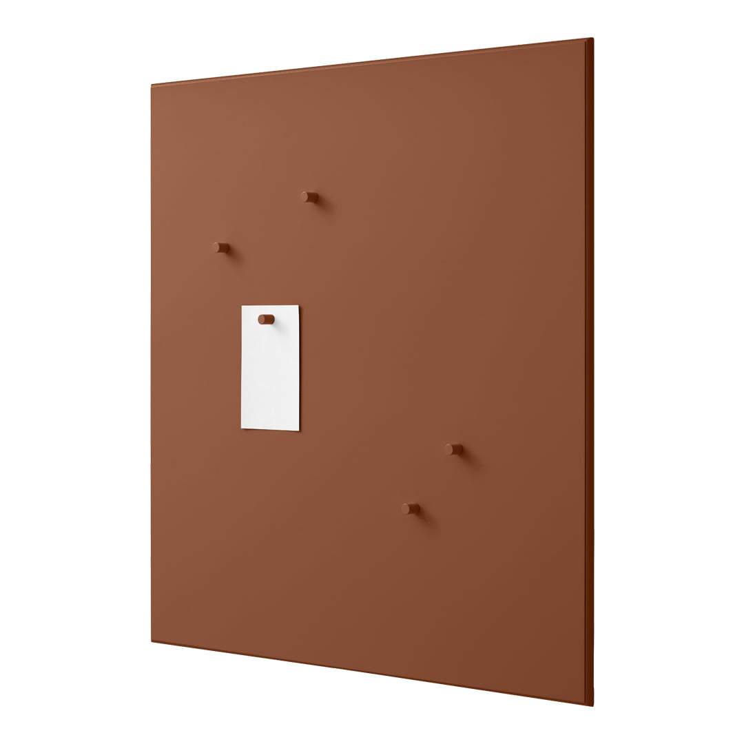 Brown wall panel with white note holder and matching brown pegs, featuring a smooth, matte finish.