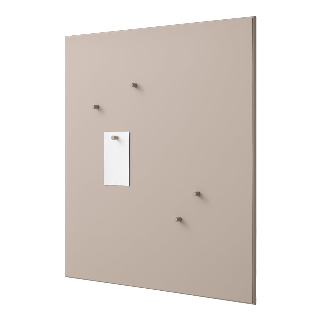 Neutral beige wall with minimalistic white note and matching hooks, creating a clean, modern aesthetic.