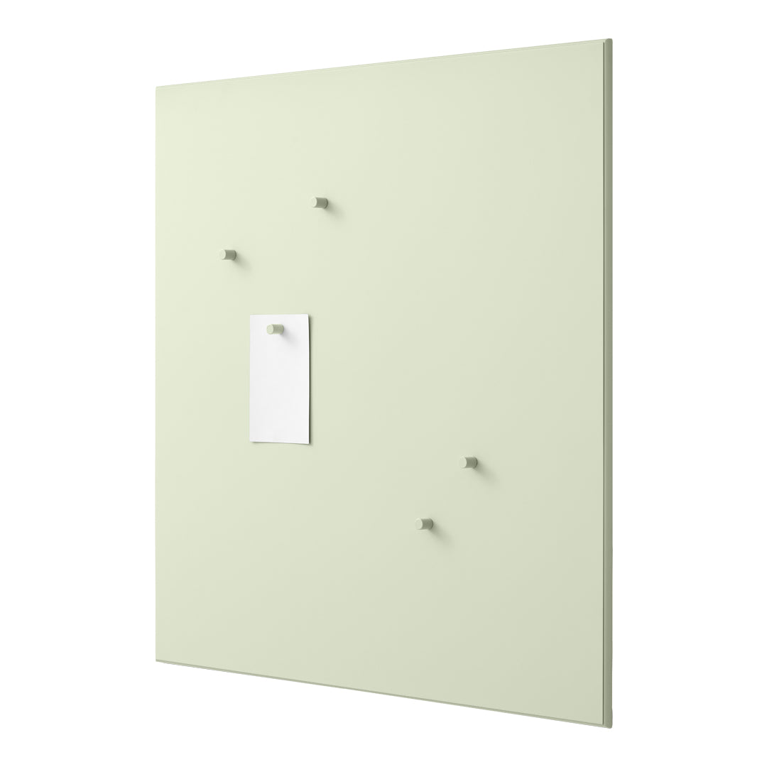 Light green wall panel with four matching pegs and a white sheet of paper for notes. Clean and modern design.
