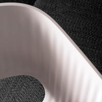 Textured black surface juxtaposed with smooth pink curve, highlighting contrasting colors and patterns.