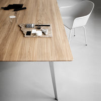 Light oak wood table with a smooth grain, featuring black and white decorative objects on a gray surface.