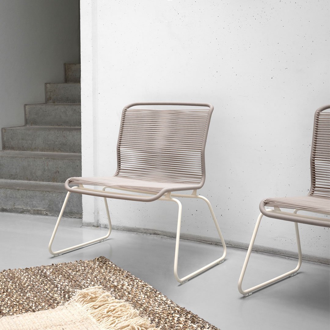 Modern beige chair with sleek lines and woven pattern, paired with a light cream frame. Ideal for minimalist decor.