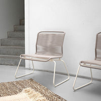 Modern beige chair with sleek lines and woven pattern, paired with a light cream frame. Ideal for minimalist decor.