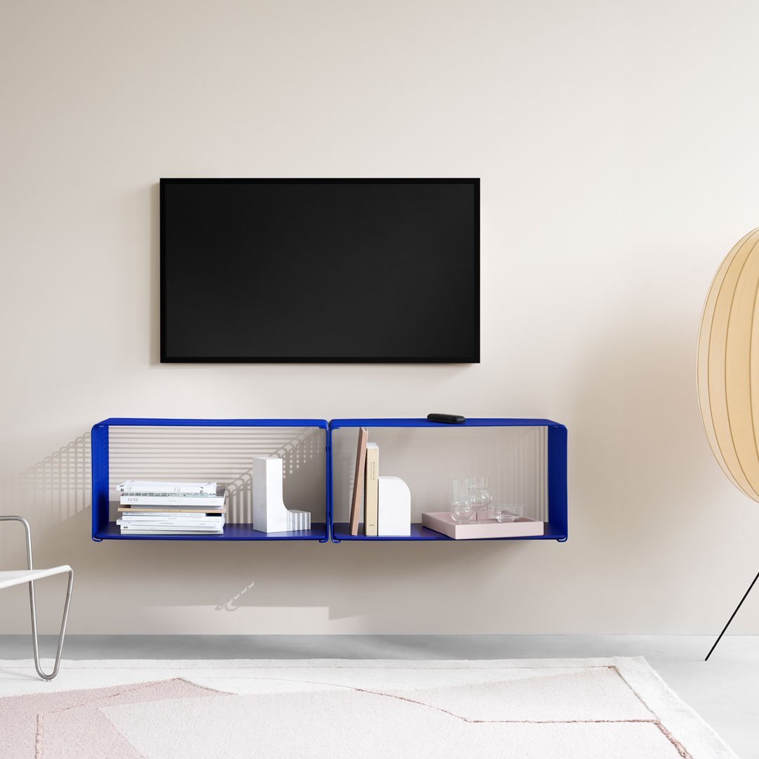 Modern blue shelf design with white accents against a neutral wall, featuring subtle geometric patterns.