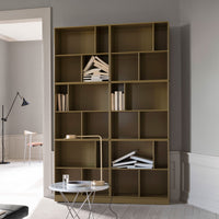 Modern olive green bookshelf with minimalist design, featuring contrasting white books against a neutral background.
