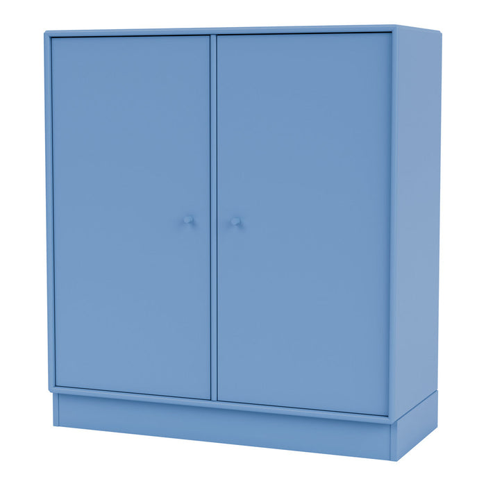 Blue storage cabinet with a smooth finish and minimalist design, featuring two doors and simple round knobs.