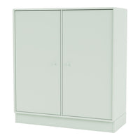 Light green storage cabinet with a smooth surface and minimalistic design, featuring two doors and round knobs.