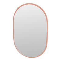 Oval mirror with a soft peach-pink frame, sleek and minimalistic design for modern decor.