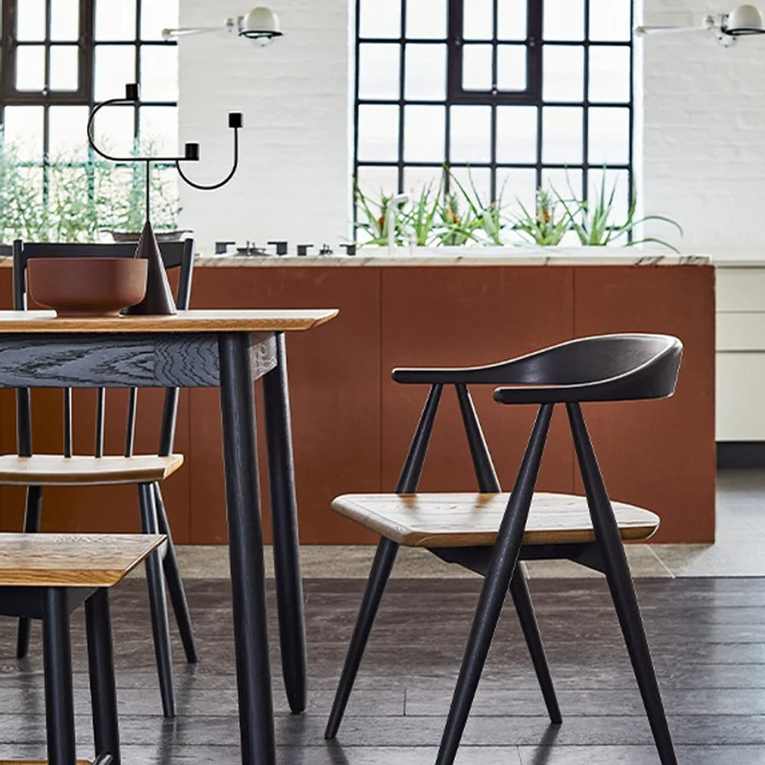 "Modern wooden table and chair set in black and natural wood tones, featuring sleek lines and minimalist design."
