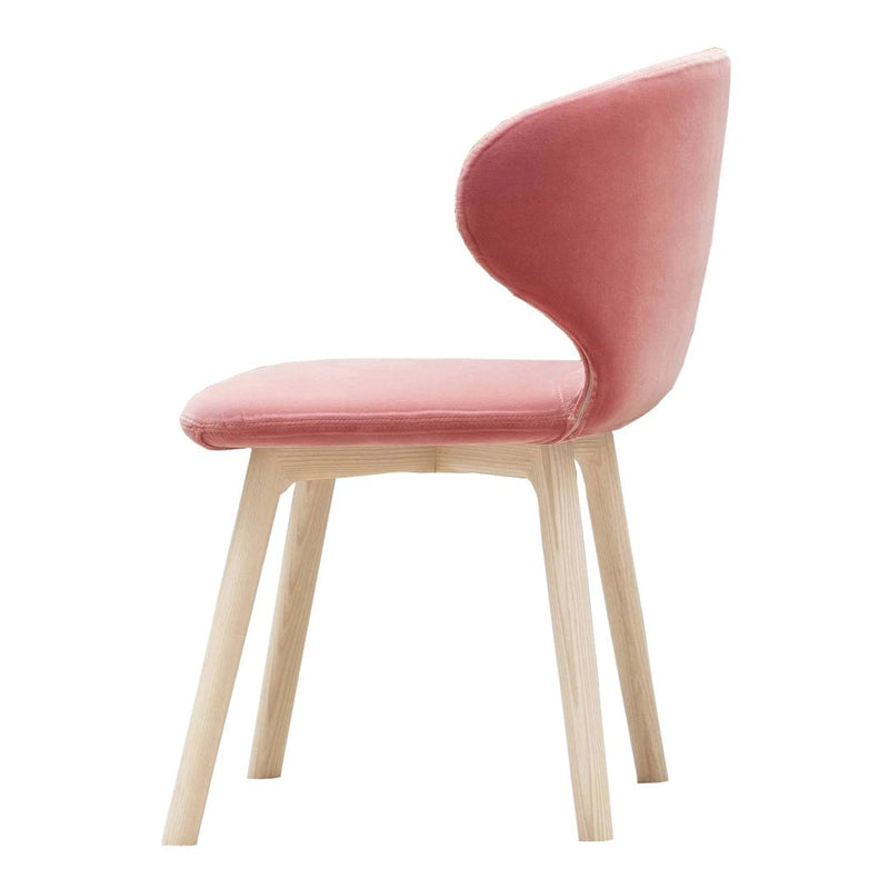 Pink velvet chair with a smooth, rounded back and light wooden legs, showcasing a modern minimalist design.