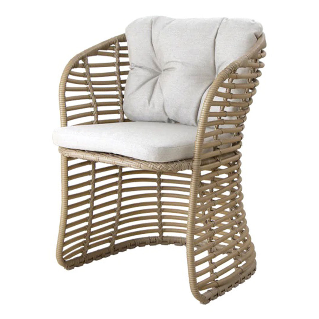 Natural woven rattan chair with a light beige cushion, featuring an open, curved pattern for a modern look.