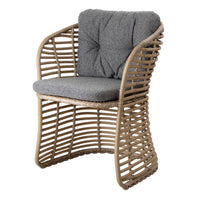 Gray cushioned chair with a woven natural rattan frame, featuring a modern, open-pattern design.