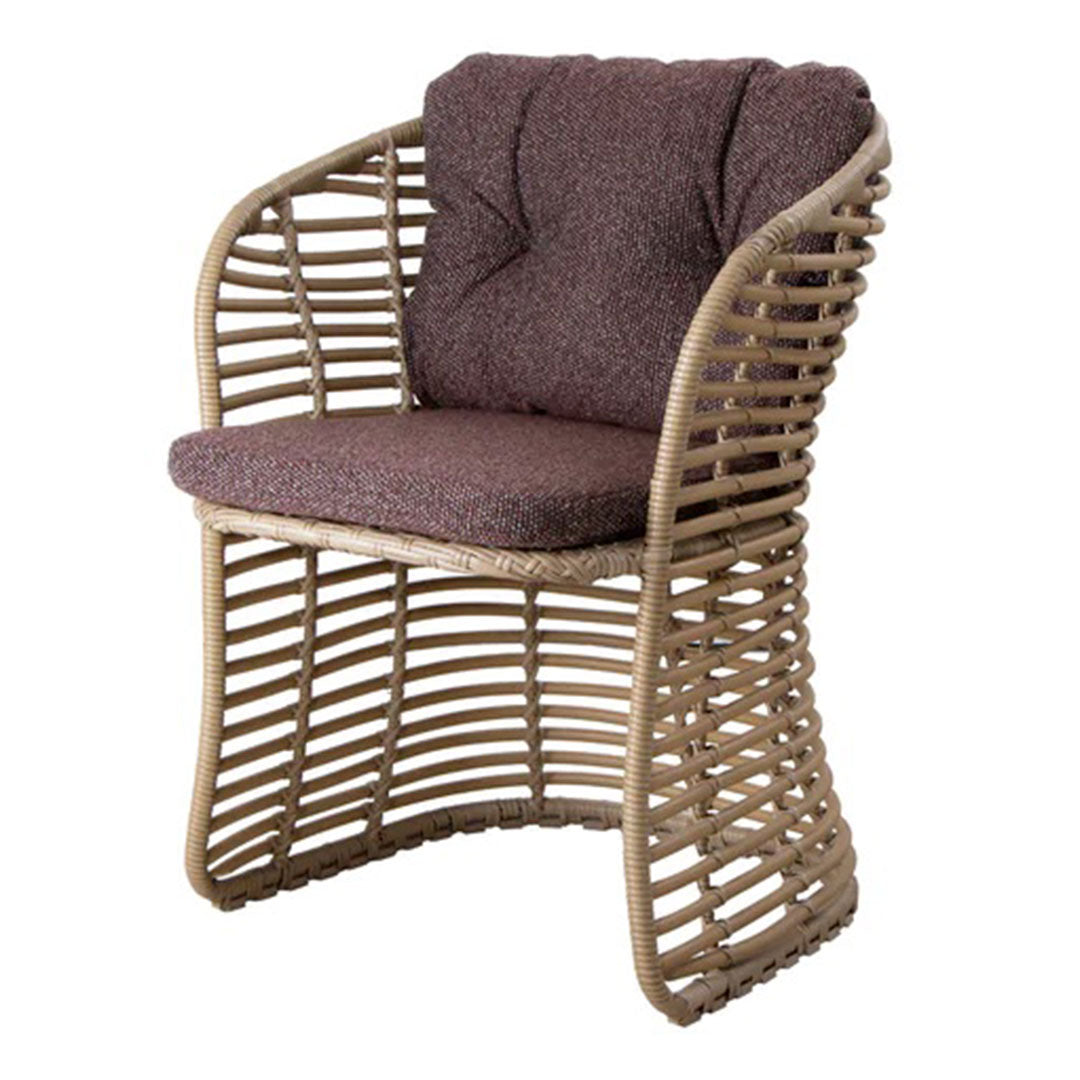 Brown textured cushion atop a woven rattan chair with natural wood tones and sleek curved design.