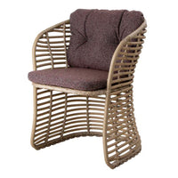 Brown textured cushion atop a woven rattan chair with natural wood tones and sleek curved design.