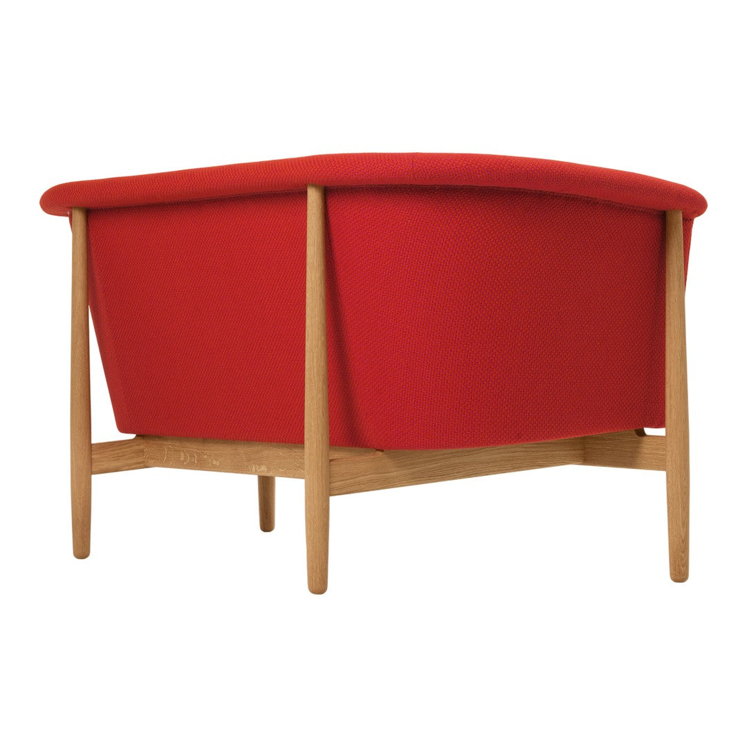 Red upholstered chair with a sleek curved design and light wood legs. Bold color perfect for modern decor.