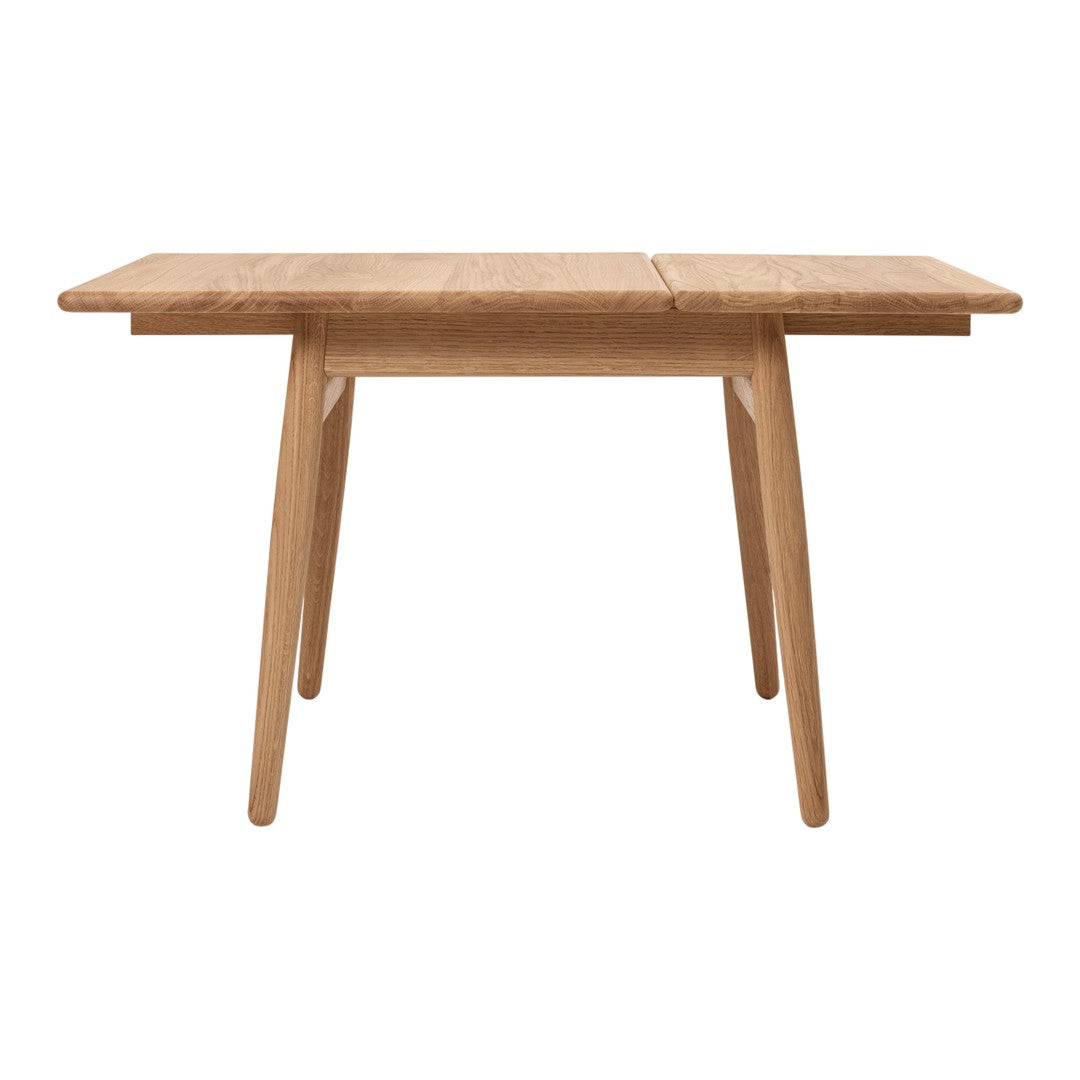 Natural wood dining table with a warm, light oak finish and clean, minimalist design. Perfect for any dining space.