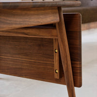 Rich walnut wood grain with warm brown tones and sleek, minimalist design featuring brass hardware accents.