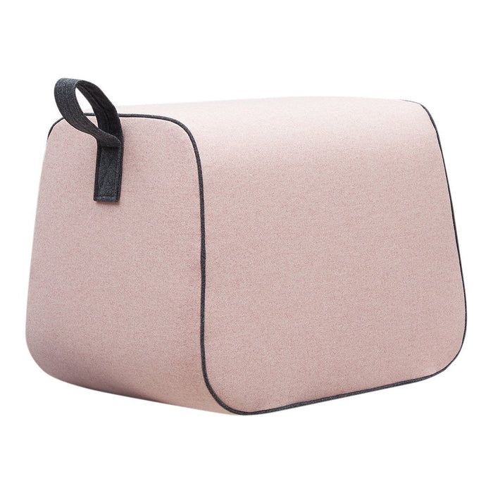 Soft pink accent pouf with a textured finish and contrasting black edges. Ideal for modern decor.