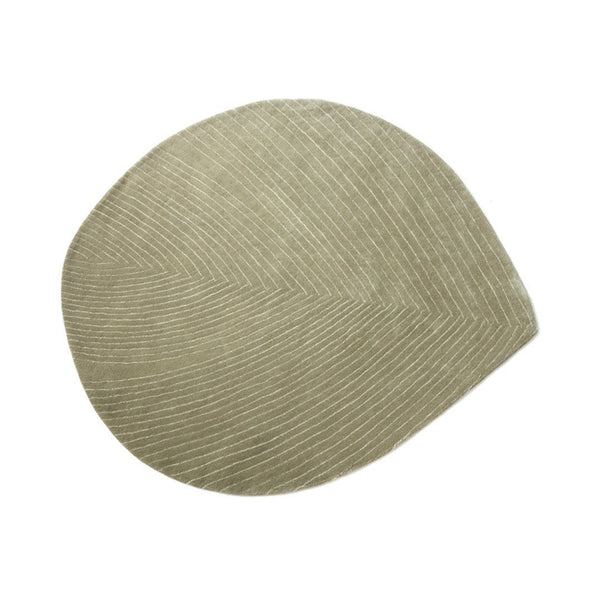 Beige leaf-shaped mat with textured lines and a soft, modern design, perfect for contemporary home decor.