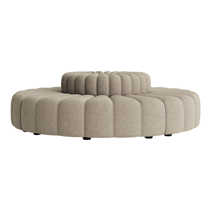 Beige tufted round ottoman with a layered design, featuring soft curves and a contemporary texture.