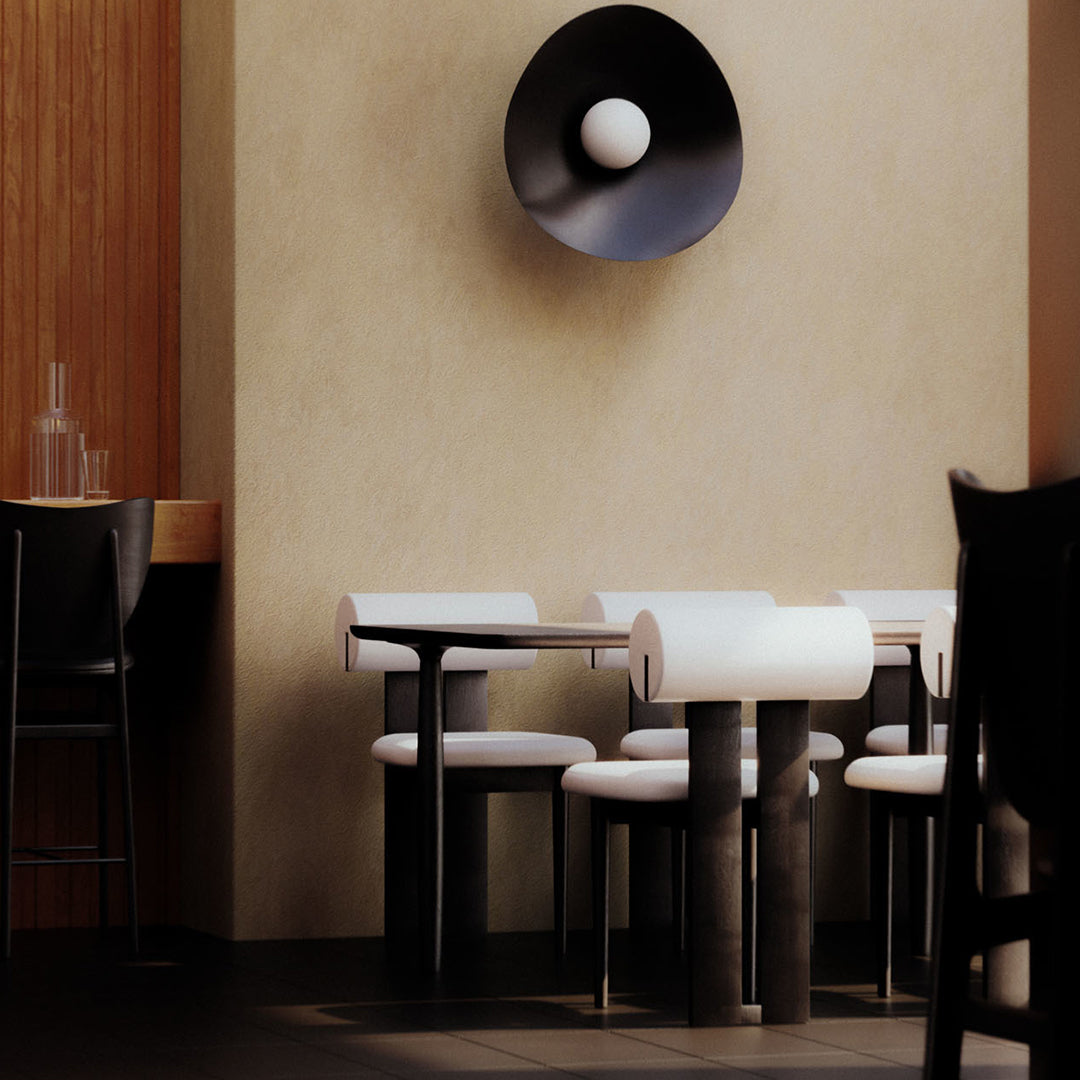 Modern black and white furniture with bold geometric patterns in a warm, neutral-toned interior.