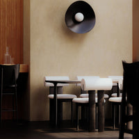 Modern black and white furniture with bold geometric patterns in a warm, neutral-toned interior.