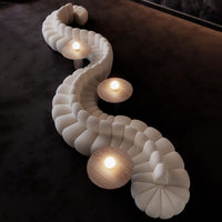 Curved cream-textured sofa with round cream and wooden accents, highlighting a modern and elegant design.