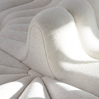 Cream textured upholstered seating with a wave pattern and soft lines, creating a modern aesthetic.