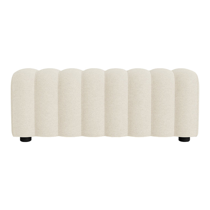 Cream-colored upholstered bench with a ribbed pattern and black feet, perfect for modern decor.