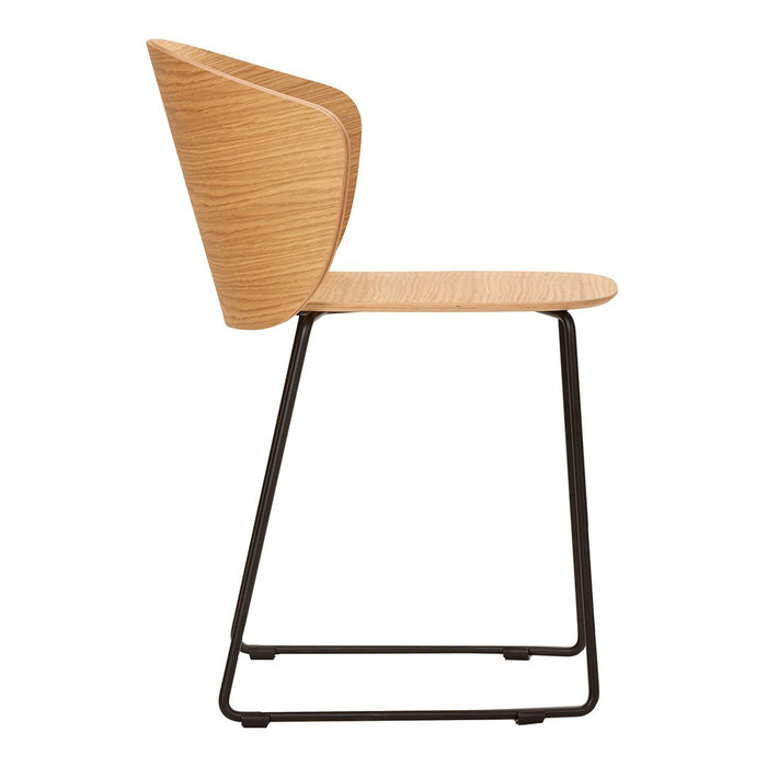 Minimalist wooden dining chair in natural oak finish with a sleek black metal base.