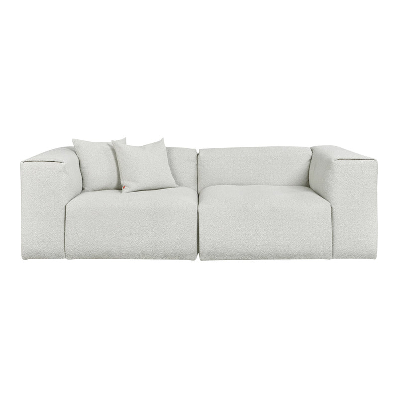 Textured light gray sectional sofa with matching cushions, featuring a minimalist design and soft fabric finish.