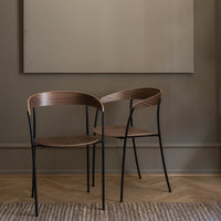Modern brown wood chairs with sleek black metal frames, featuring smooth curves and minimalist design.