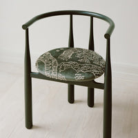 Green chair with patterned cushion on a light wooden floor