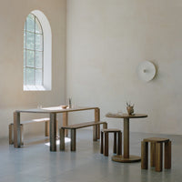 Warm wood tones with smooth finishes; simple, modern shapes against light beige walls and grey tiles.